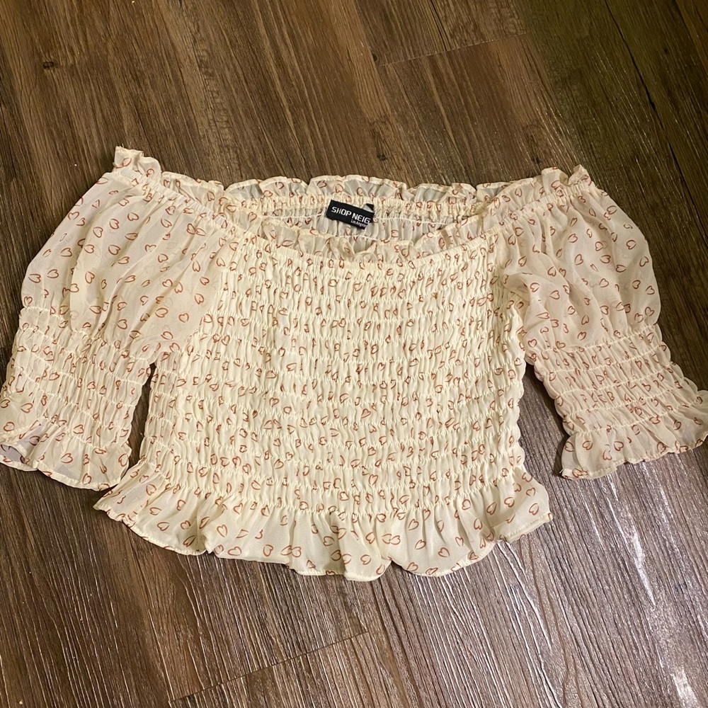 Off the shoulder cropped top. Super
cute and flirty with the heart design!